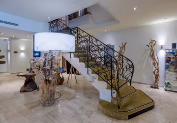 Hall de l'hôtel, avec son escalier en fer forgé et sa lampe en bois flotté