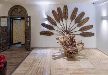 Hall de l'hôtel avec une sculpture en bois flotté et un décor de feuilles de palmier