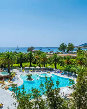 Piscine et jardin de palmiers, avec la mer et le golfe d'Ajaccio au fond