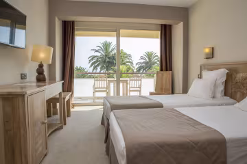 Chambre à deux lits avec balcon donnant sur les palmiers