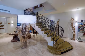 Hall de l'hôtel, avec son escalier en fer forgé et sa lampe en bois flotté